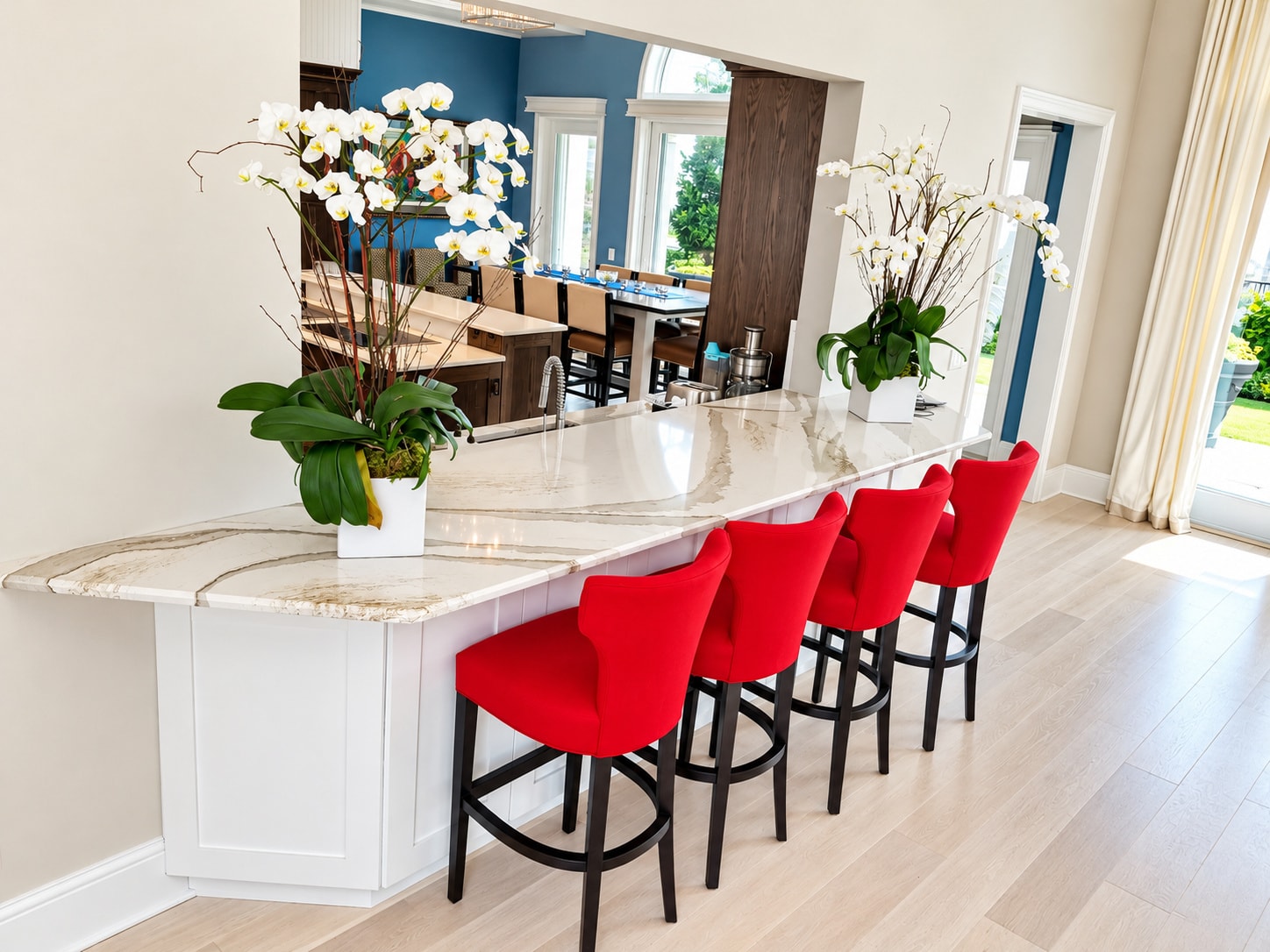 Kitchen island with marble countertop and red bar stools