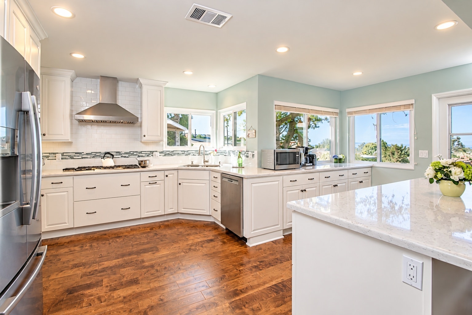 White kitchen with quartz countertops and mosaic tile backsplash