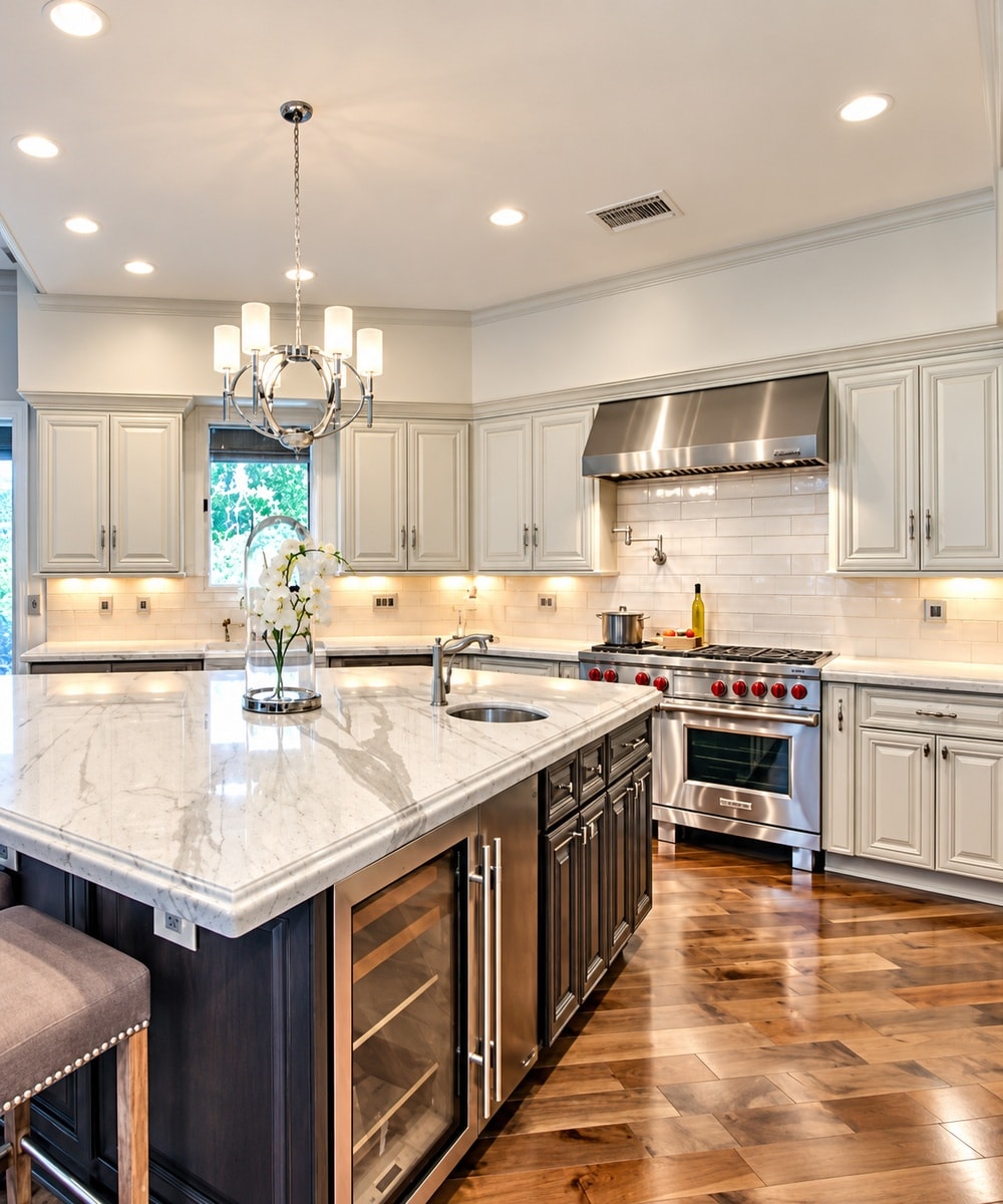 Sage green kitchen with marble island and chandelier