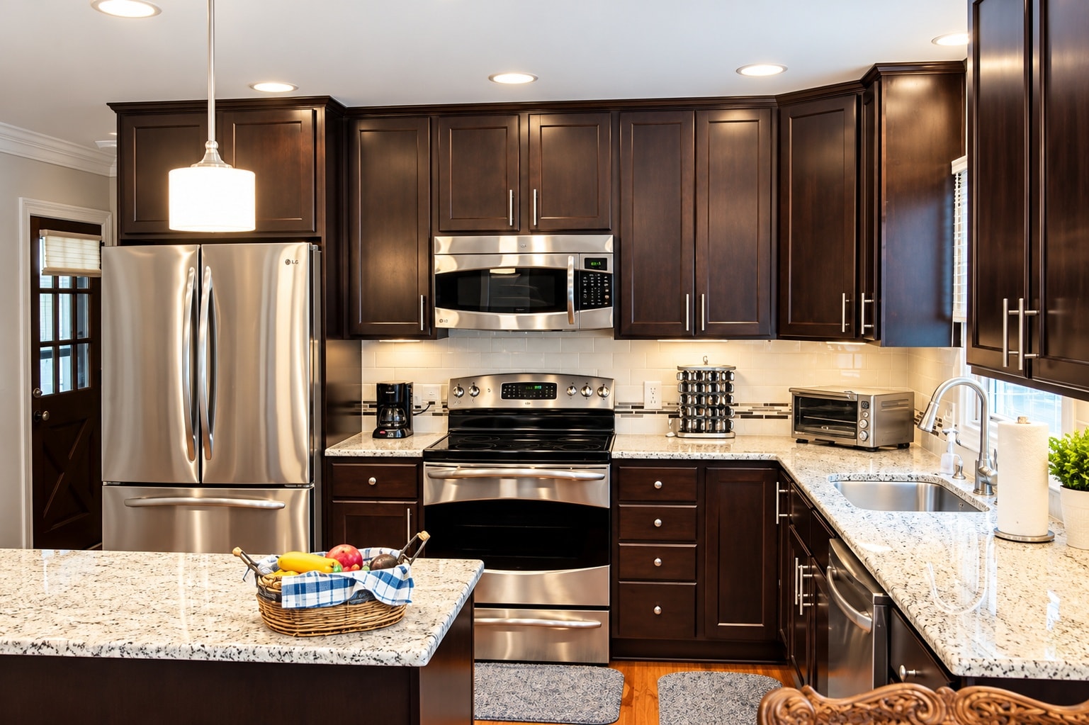 Dark espresso kitchen with stainless appliances and granite island