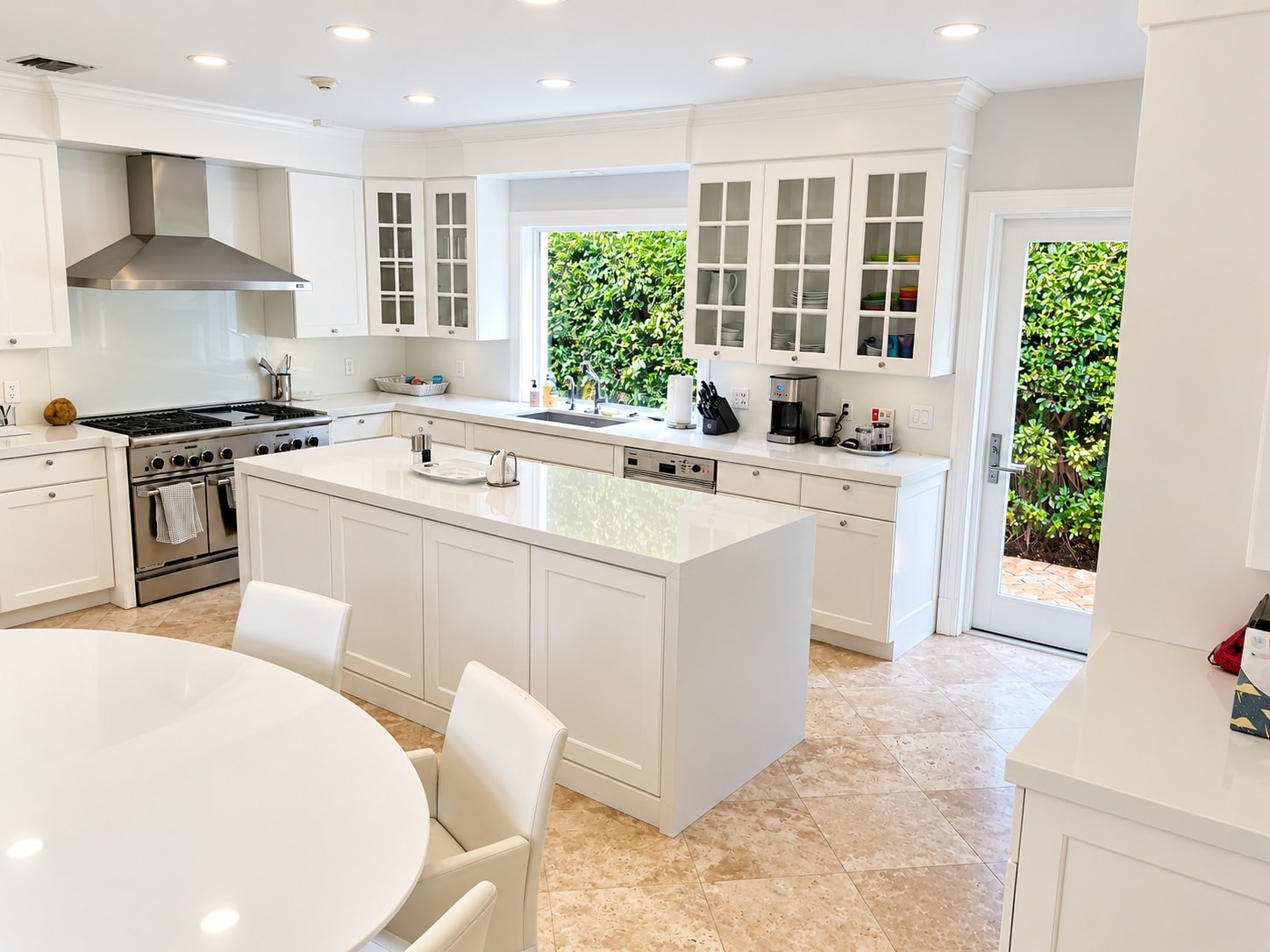 Bright white kitchen with center island and garden views