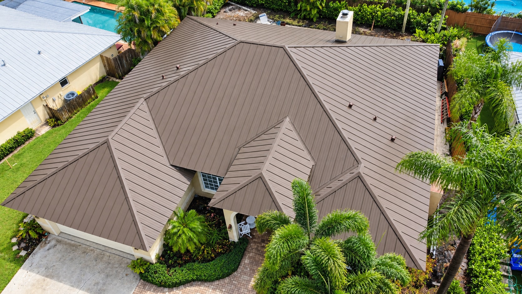 Aerial view of brown standing seam metal roof with pool
