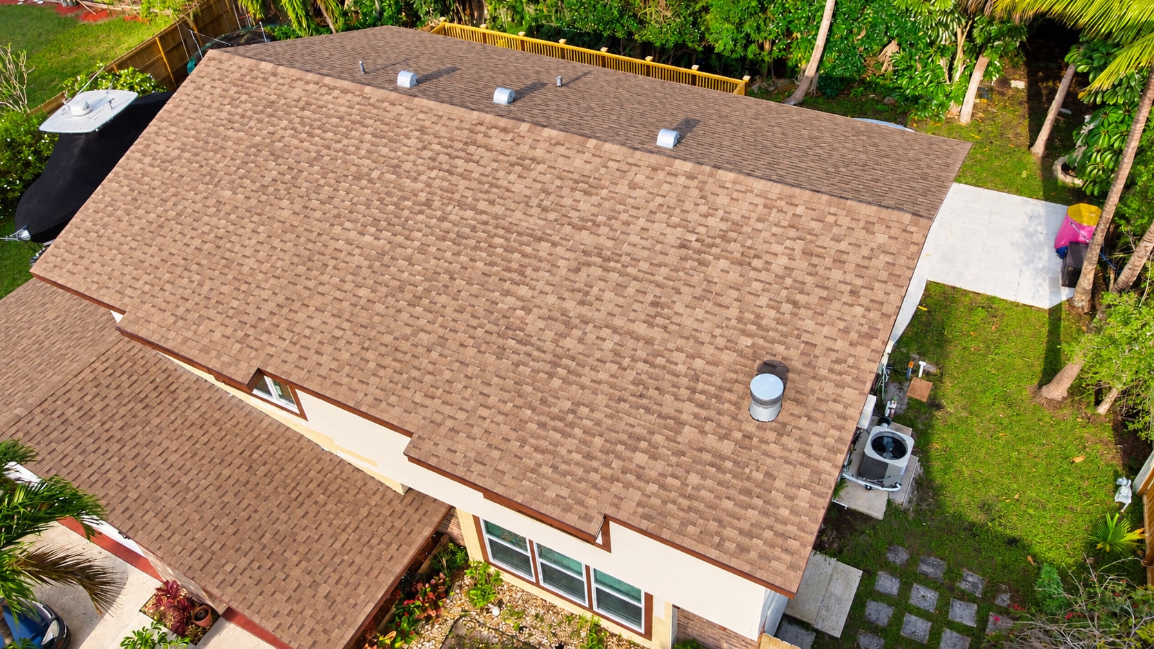 Aerial view of brown asphalt shingle roof with HVAC equipment