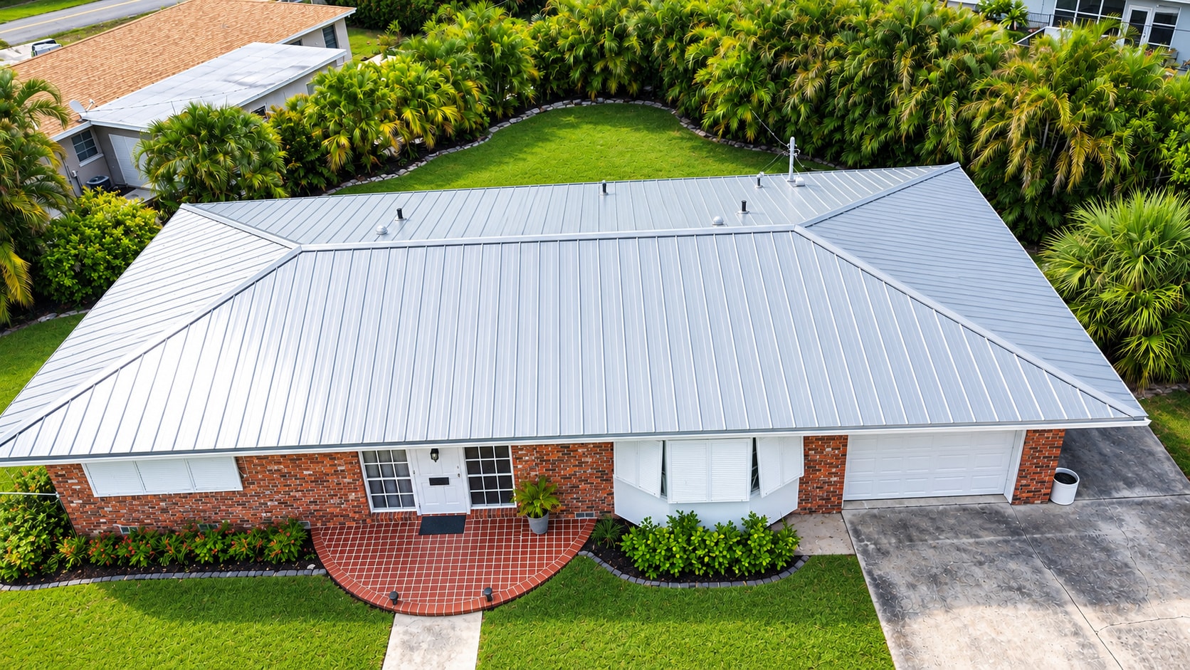 Aerial view of silver standing seam metal roof on brick home