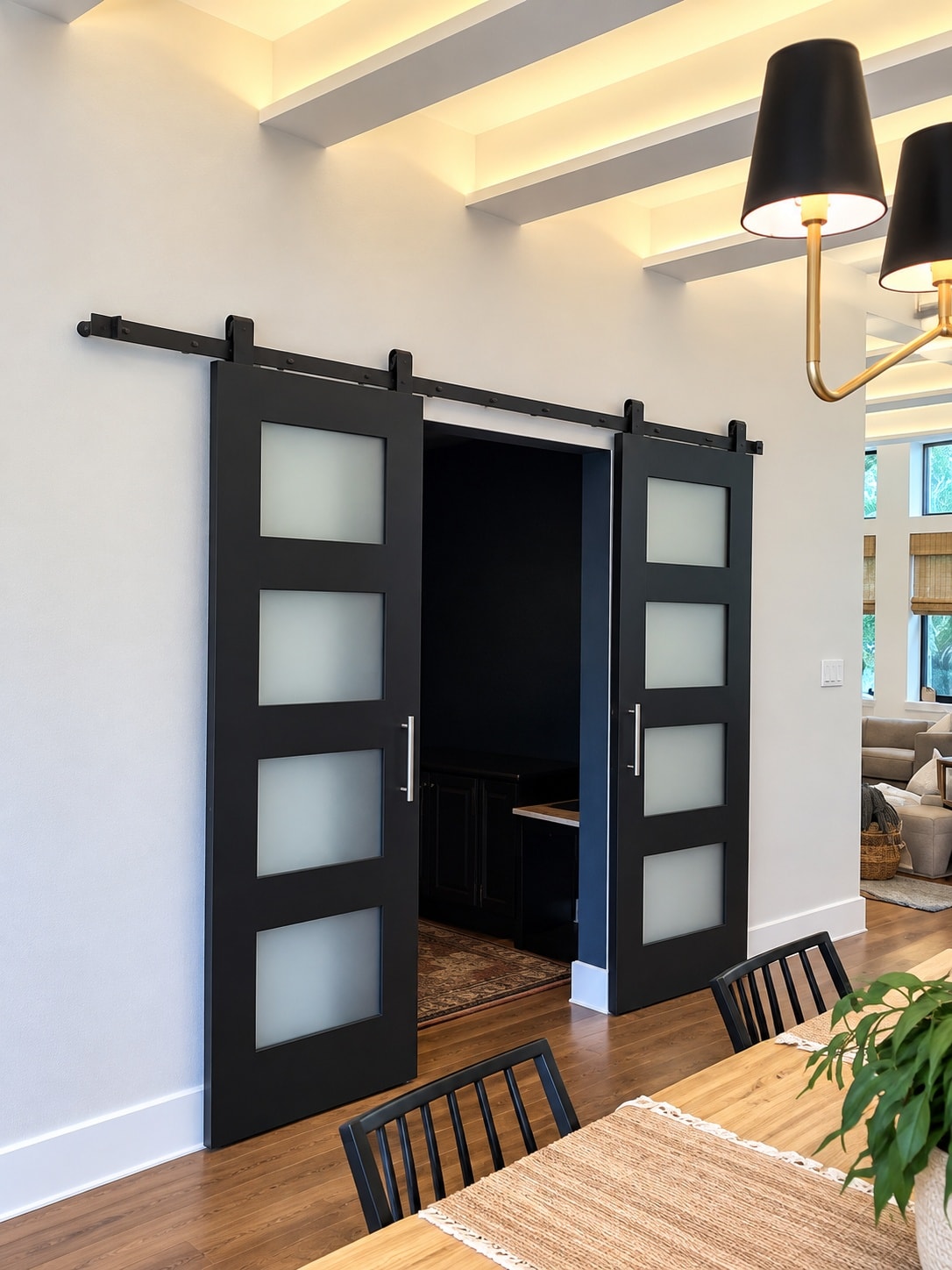Black sliding barn doors with frosted glass panels